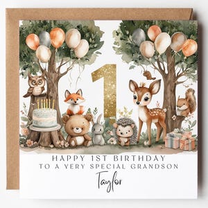 Puede incluir: Tarjeta de cumpleaños con temática de bosque. Presenta un número uno dorado con purpurina, globos y varios animales del bosque, como un ciervo, un zorro y un búho. El texto dice "Feliz 1er cumpleaños a un nieto muy especial".