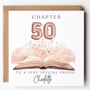 以下が含まれることがあります： 白い背景と茶色の封筒が付いた誕生日カード。カードには、ローズゴールドの風船のデザインで「CHAPTER 50」という文字が書かれています。その下には、ピンクの雲と紙吹雪のある開いた本があります。カードには「TO A VERY SPECIAL FRIEND」と書かれており、「Charlotte」と署名されています。
