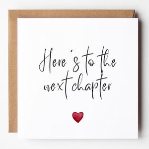 Könnte beinhalten: Eine weiße Grußkarte mit dem Text "Here's to the next chapter" in schwarzer Schrift und einem kleinen roten Herz. Die Karte befindet sich in einem braunen Umschlag.