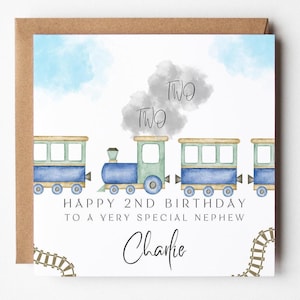 Può includere: Biglietto di compleanno con un design di treno ad acquerello. Il biglietto presenta un treno blu e verde con le parole "TWO" e "Happy 2nd Birthday to a very special nephew, Charlie". Il biglietto è su una busta marrone.