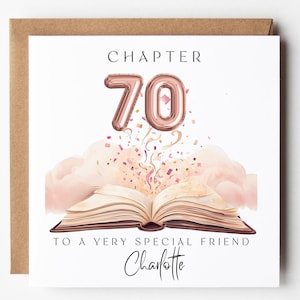 May include: A square greeting card featuring an open book with rose gold balloon numbers 70 floating above it, surrounded by pink clouds and confetti. The text reads CHAPTER 70 TO A VERY SPECIAL FRIEND Charlotte in black serif and script fonts.