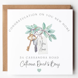 May include: A white card with the text "CONGRATULATION ON YOU NEW HOME" in a curved font. The card features a watercolor illustration of keys, greenery, and a tag that says "New Home". The address and names are also printed on the card.