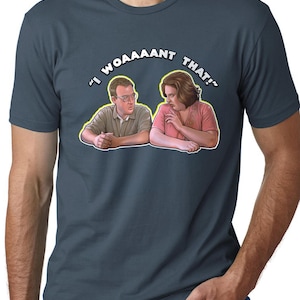 May include: A dark blue t-shirt featuring a graphic of two people. The text on the shirt reads "I WOAAANT THAT!"