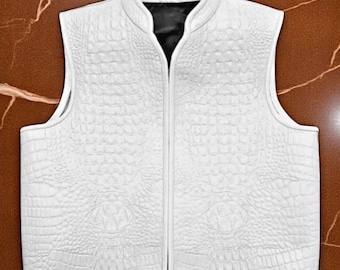 May include: A white vest with a textured, crocodile-like pattern. The vest has a stand-up collar and a full-length zipper. The interior lining is black. The vest is sleeveless and appears to be made of leather or a similar material.