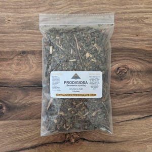 May include: A transparent plastic bag filled with dried herbs, labelled "PRODIGIOSA (Swietenia humilis)". The bag contains 113g of raw and pure herbs. The label also includes the website address: www.ANCIENTRESONANCE.COM.