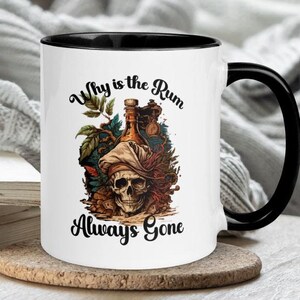 May include: White ceramic mug with a black rim and handle. The mug features a skull with a pirate hat and a bottle of rum. The text on the mug reads "Why is the Rum Always Gone".