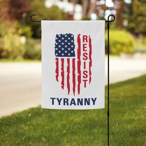 May include: A white garden flag with a distressed American flag design and the words "Resist Tyranny" in red letters.