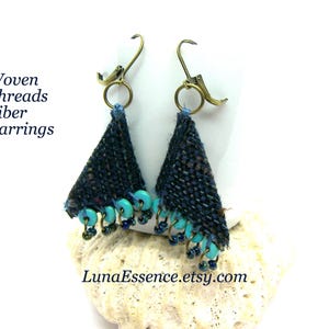 May include: A pair of dark blue woven fiber earrings with turquoise and dark blue bead accents. The earrings have a triangular shape and are suspended from gold-colored lever-back ear wires. Text on the image reads "Woven Threads Fiber Earrings" and "LunaEssence.etsy.com".