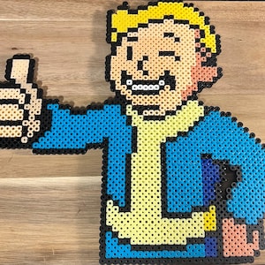May include: A pixel art character made of colorful beads, depicting a person with blonde hair, a yellow shirt, and a blue jacket. The character is giving a thumbs up.