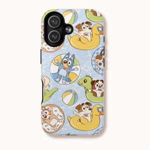 May include: A phone case featuring a repeating pattern of cartoon dogs and characters in inflatable pool toys, such as a duck, donut, and dinosaur, on a light blue background with water ripples.