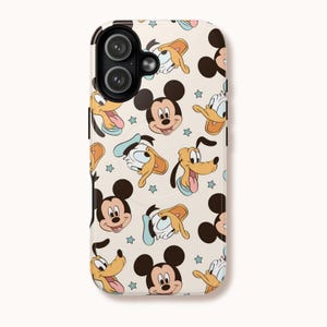 May include: A phone case with a repeating pattern of cartoon characters. Mickey Mouse, Donald Duck, and Pluto are shown in a vintage style, set against a cream background with small blue star accents. The case has a black border around the camera.