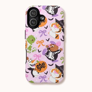 Puede incluir: Funda de teléfono rosa claro con un diseño temático de Halloween. El diseño incluye personajes de dibujos animados como un tigre, un ratón y un muñeco de nieve, todos disfrazados para Halloween. La funda también tiene calabazas naranjas, murciélagos y la palabra "BOO!"