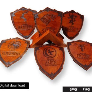 Puede incluir: Seis posavasos de madera con los escudos y nombres de diferentes casas de la popular serie de televisión de fantasía Juego de Tronos. Los posavasos tienen forma de escudo y tienen un acabado de madera marrón oscuro.