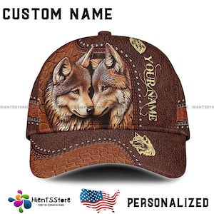 Puede incluir: Gorra de béisbol marrón con una ilustración detallada de dos lobos. La gorra tiene una textura similar al cuero con el texto "CUSTOM NAME" y "YOUR NAME" impreso. La palabra "PERSONALIZED" también es visible.