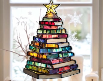 May include: A stained glass Christmas tree ornament. The tree is made of colorful, stacked books, topped with a yellow star. The books have red, green, blue, and yellow hues. The ornament hangs from a silver chain.