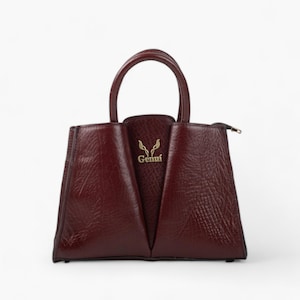 Bolso de piel burdeos con forma de V: elegancia artesanal y lujo práctico