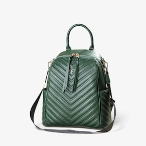 May include: A dark green backpack featuring a chevron-stitched pattern on the front panel. The bag includes a top handle, gold-toned zipper pulls with long leather-like tabs, a central gold letter F logo, and a black adjustable shoulder strap.