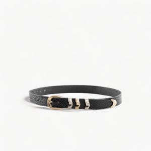 May include: A black leather belt with a gold buckle and silver accents. The belt has a textured finish and is approximately 1 inch wide.