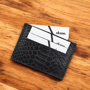 Tarjetero fino de piel negra con relieve: un elegante accesorio para el día a día.