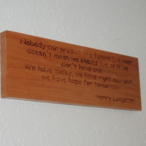 Puede incluir: Un letrero de madera con una cita de Henry Langston: "Nadie puede predecir el futuro, pero eso no significa que debamos vivir como si no lo tuviéramos. Tenemos hoy, tenemos ahora y tenemos esperanza para mañana."