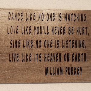 May include: A wooden sign with a quote by William Purkey: "Dance like no one is watching, love like you'll never be hurt, sing like no one is listening, live like it's heaven on earth."