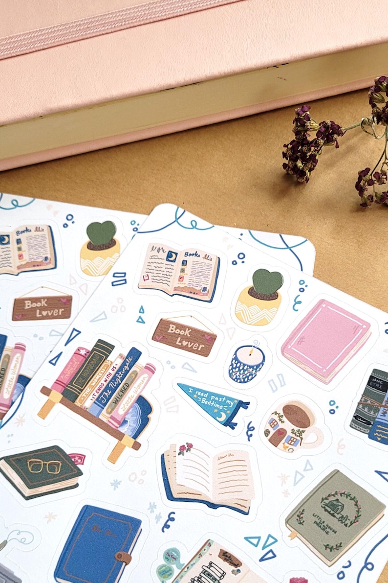 May include: A collection of stickers with a book theme. The stickers feature open books, stacks of books, potted plants, and the text "Book Lover". The color palette includes pink, blue, green, and brown.