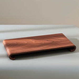 Peut inclure: Plateau rectangulaire en bois avec des bords incurv&eacute;s et sur&eacute;lev&eacute;s. Fabriqu&eacute; en bois brun fonc&eacute; avec un motif de grain visible. Design minimaliste et moderne, id&eacute;al pour le service ou l'exposition. Mesure environ 30 cm de long.