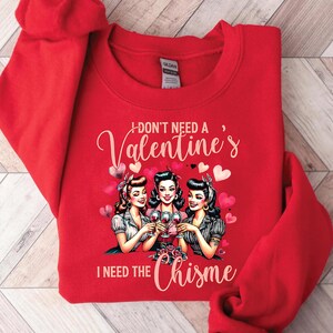 May include: Red sweatshirt with a graphic of three women holding wine glasses and the text "I don't need a Valentine's I need the Chisne".