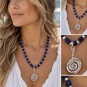 May include: A necklace featuring a series of cylindrical dark blue beads alternating with small, round, polished silver-toned beads. The necklace includes a central silver-toned pendant shaped like a spiral, suspended from a simple silver-toned bail.