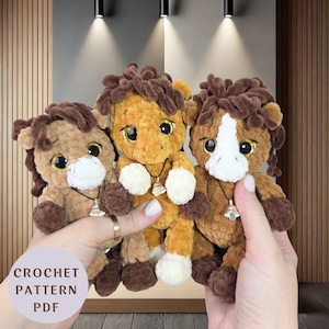 Peut inclure: Trois peluches de chevaux au crochet faites à la main, dans des tons de marron et de beige. Chaque peluche a une crinière touffue, des accents blancs et un petit collier clochette. Le texte "CROCHET PATTERN PDF" est visible.