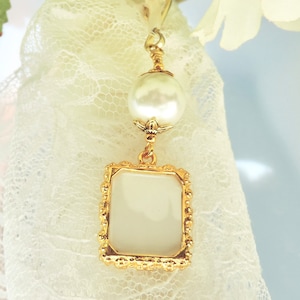 A lovely wedding bouquet photo charm in golden tones featuring an ivory, white, blue or pink shell pearl bead and small picture frame. 
What a thoughtful bridal shower gift. Just add your picture of a loved one, or let me do the photo too :)