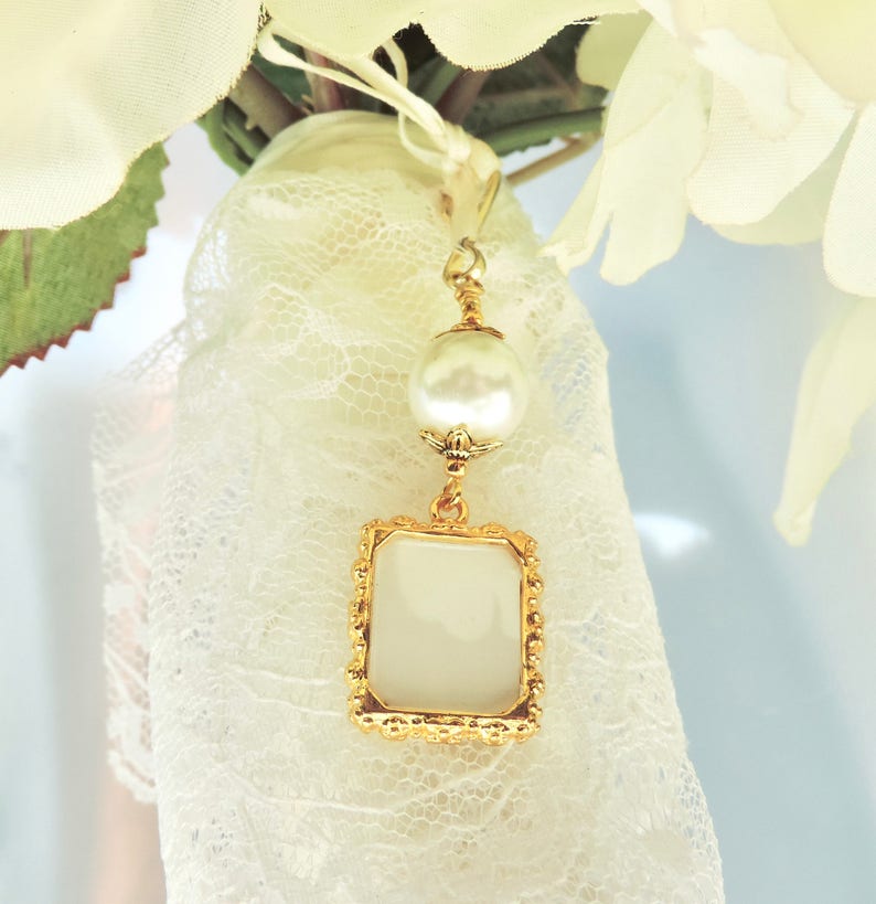 A lovely wedding bouquet photo charm in golden tones featuring an ivory, white, blue or pink shell pearl bead and small picture frame. 
What a thoughtful bridal shower gift. Just add your picture of a loved one, or let me do the photo too :)