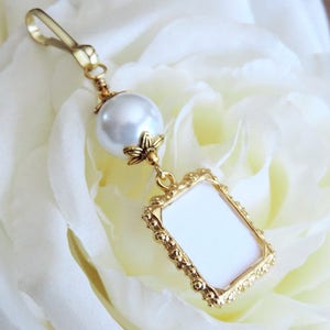 A lovely wedding bouquet photo charm in golden tones featuring an ivory, white, blue or pink shell pearl bead and small picture frame. 
What a thoughtful bridal shower gift. Just add your picture of a loved one, or let me do the photo too :)