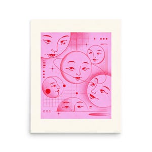 May include: A rectangular art print featuring a pink background with multiple red celestial faces. The design includes a central planet with rings, various moon phases, and geometric grid patterns, all rendered in a stylized, graphic illustration.
