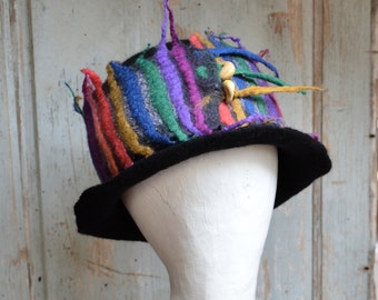 Handmade felt hat, made with black merino wool in a bohemian style with a nuno felted scarf in rainbow colors