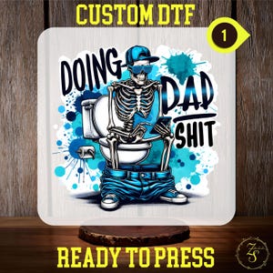 May include: A skeleton wearing a blue baseball cap and sunglasses sits on a toilet with a phone in its hand. The text "Doing Dad Shit" is written in blue and white letters on a white background with blue watercolor splatters.