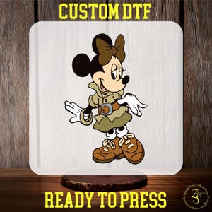 May include: A cartoon image of a mouse wearing a brown and green safari outfit with a brown belt and a brown hat. The mouse is standing with its right leg forward and its left leg back. The mouse is looking to the right. The image is on a white background.