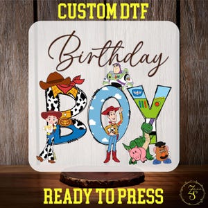 May include: A white background with the words "Custom DTF Birthday Boy" in black lettering. The letters are decorated with images of characters from the Toy Story movie franchise, including Woody, Buzz Lightyear, and Rex. The words "Ready to Press" are written in yellow lettering at the bottom of the image.