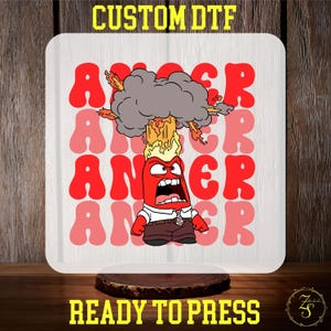 May include: A white sublimation blank with a red cartoon character with a red face and a black tie. The character is surrounded by the word "ANGER" in a retro font. The character has a red, orange, and yellow explosion above his head. The text "CUSTOM DTF" is at the top of the image and "READY TO PRESS" is at the bottom.