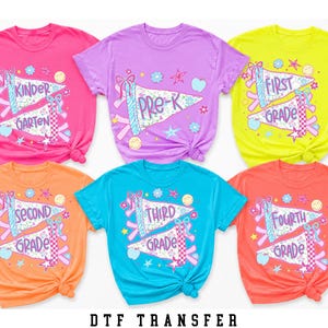 May include: Six short-sleeved t-shirts in bright pink, purple, neon yellow, orange, teal, and coral. Each shirt features a graphic of two pennants with school grade text including Kinder Garten, Pre-K, First Grade, Second Grade, Third Grade, and Fourth Grade.