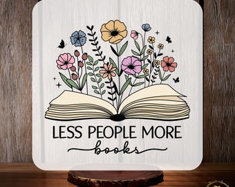 May include: A white iron-on transfer design featuring an open book with flowers and the text "Less People More Books".