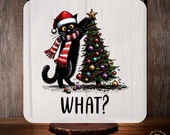 May include: A white square featuring a cartoon black cat in a Santa hat and scarf, beside a decorated Christmas tree. The word "WHAT?" is below the cat. The text "CUSTOM DTF" and "READY TO PRESS" are at the top and bottom.