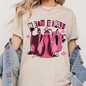 Hero mockup of Mean Girls villains DTF transfer featuring Maleficent, Cruella, and Evil Queen in pink retro style, funny Halloween ready to press design.

Close-up of Disney villains Mean Girls DTF print with pink dresses, kiss marks, and retro lettering, humorous Halloween apparel design.