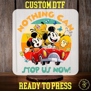 May include: A white iron-on transfer design featuring Mickey Mouse, Minnie Mouse, and Pluto driving a red car with the text "Nothing Can Stop Us Now!" in a retro style.
