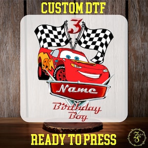 May include: Red cartoon race car with checkered flags and the text "Name Birthday Boy" on a white background.  Ready to press.