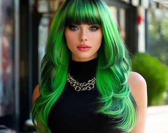 May include: A woman with a long, layered green and black wig with a fringe. She wears a black polo neck top and a gold chain necklace. The background is blurred, with outdoor elements visible.