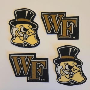 Puede incluir: Cuatro parches bordados con el logotipo de los Demon Deacons de Wake Forest. Dos parches representan la mascota de la escuela, un hombre con sombrero de copa, y dos presentan las letras "WF" en dorado sobre fondo negro. Cada parche tiene un borde blanco.