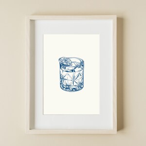 May include: A blue line drawing of a cocktail in a cut glass tumbler with a lime wedge garnish.