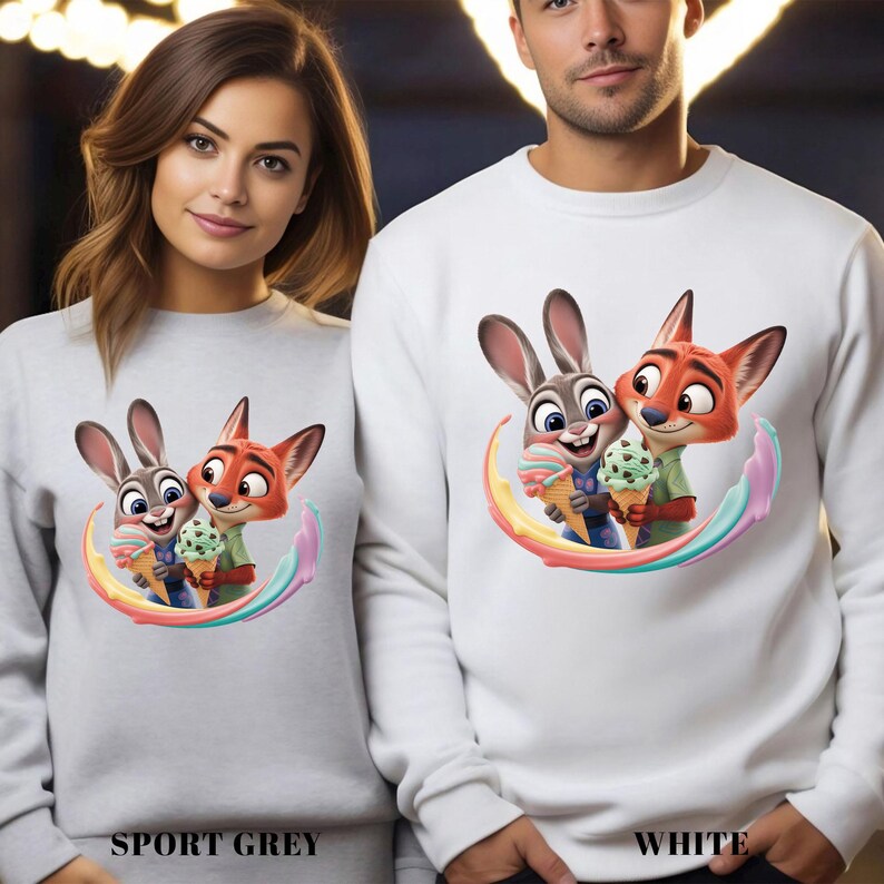 May include: Sport grey and white sweatshirts featuring a colorful cartoon image of Judy Hopps and Nick Wilde from Zootopia holding ice cream cones. The sweatshirts have the words "SPORT GREY" and "WHITE" printed at the bottom.