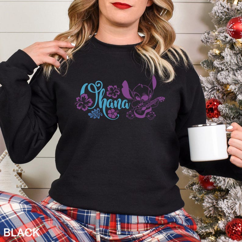 May include: Black crewneck sweatshirt with the word "Ohana" in teal and purple floral design, along with a purple cartoon character playing a ukulele. The word "BLACK" is printed at the bottom.